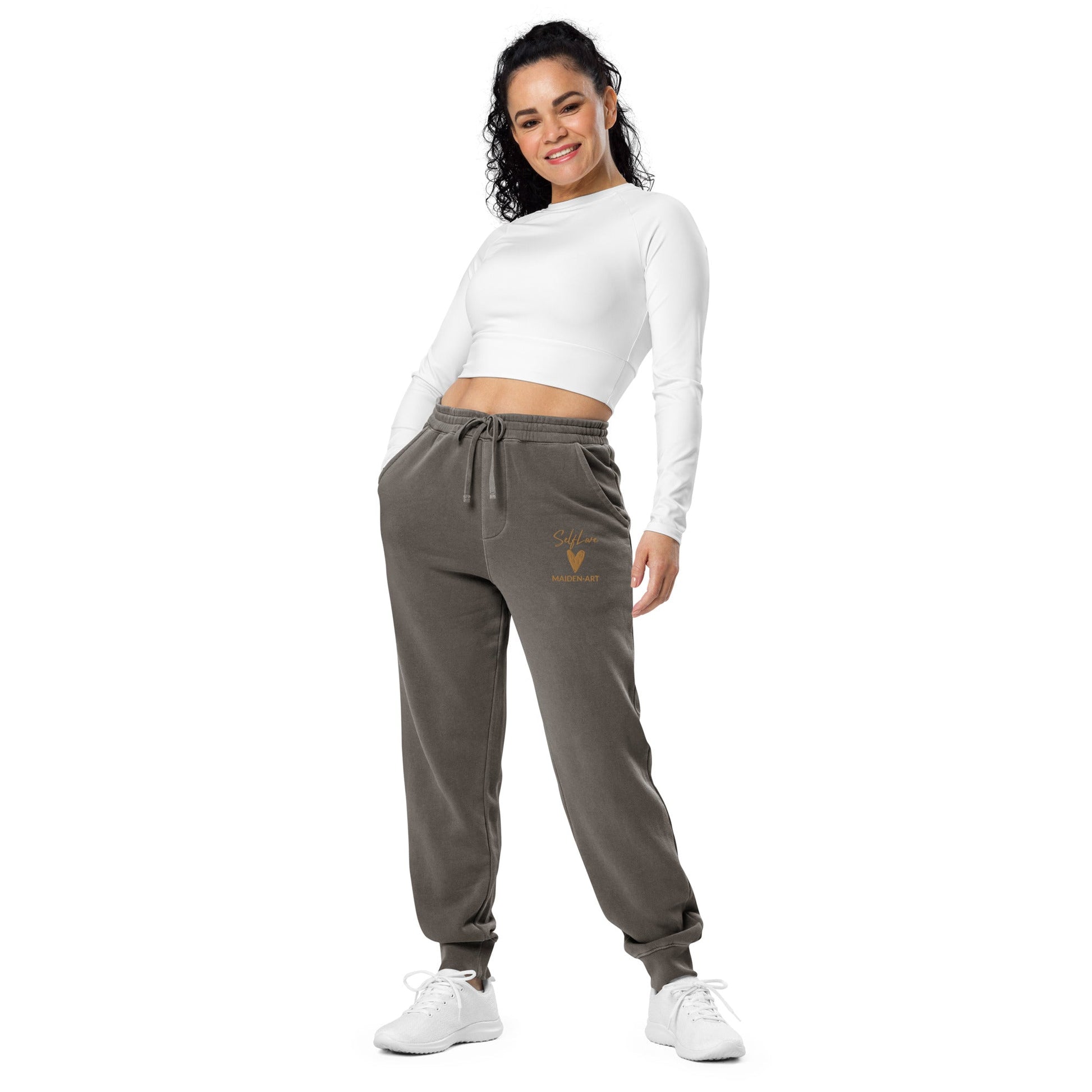Woman wearing brown jogger pants with a logo on a white background