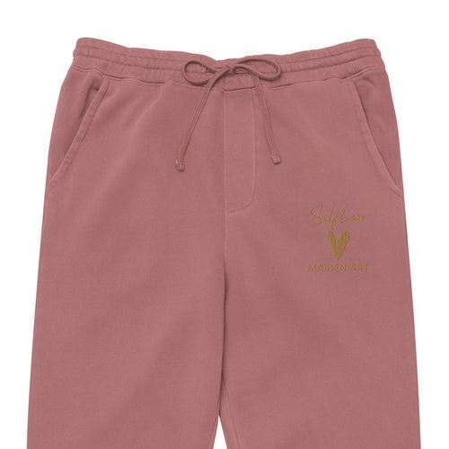 Pink sweatpants with a gold logo and text on a white background