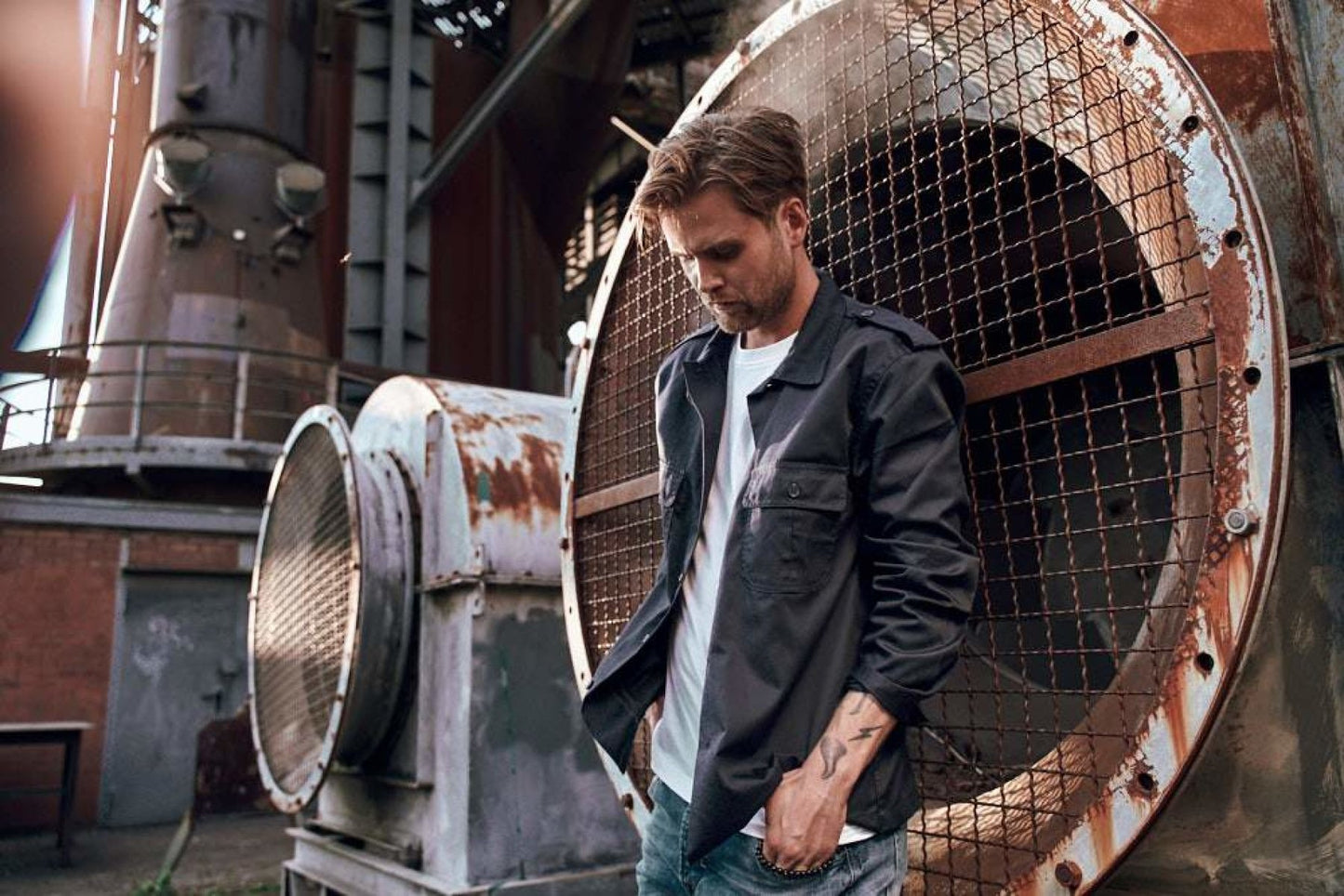 Man standing in front of a large industrial fan and metal structure