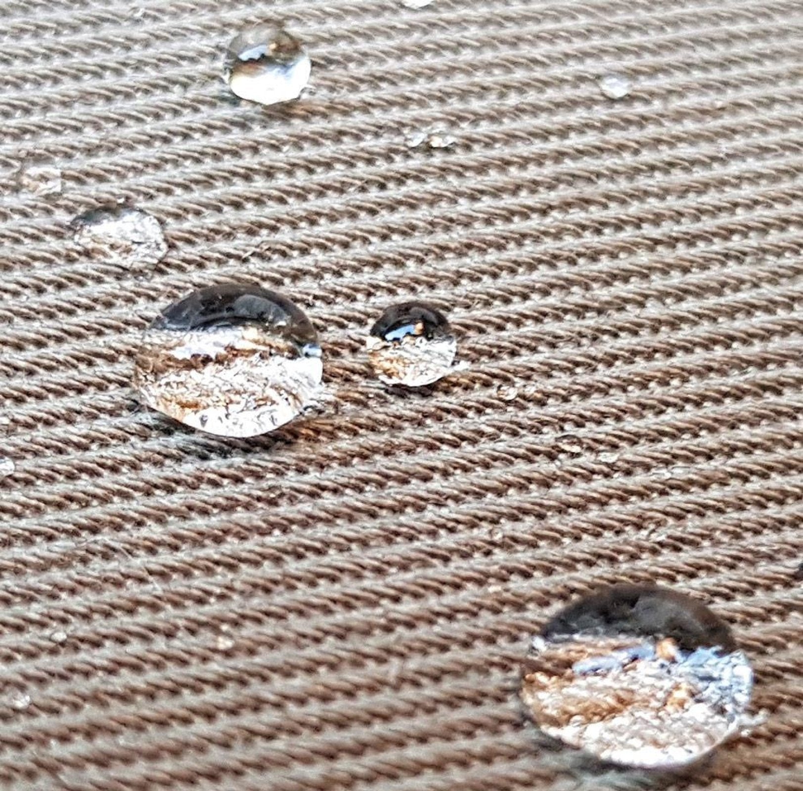 Water droplets on a textured brown surface