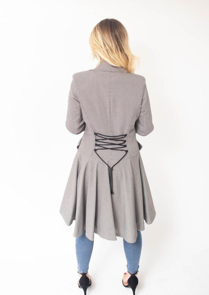 Woman wearing a gray coat with a unique back design on a white background