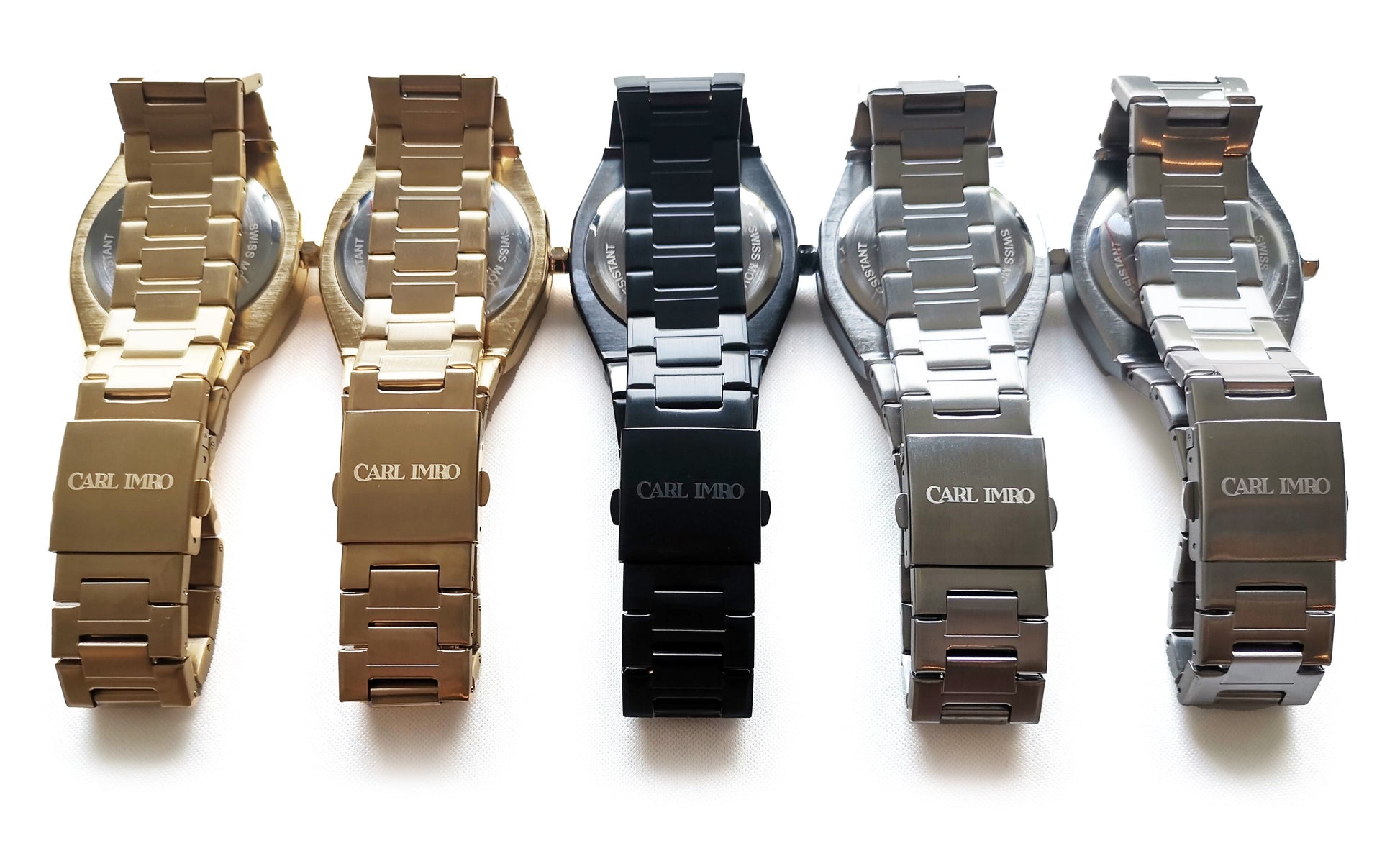 Five watches with different colored metal bands on a white background