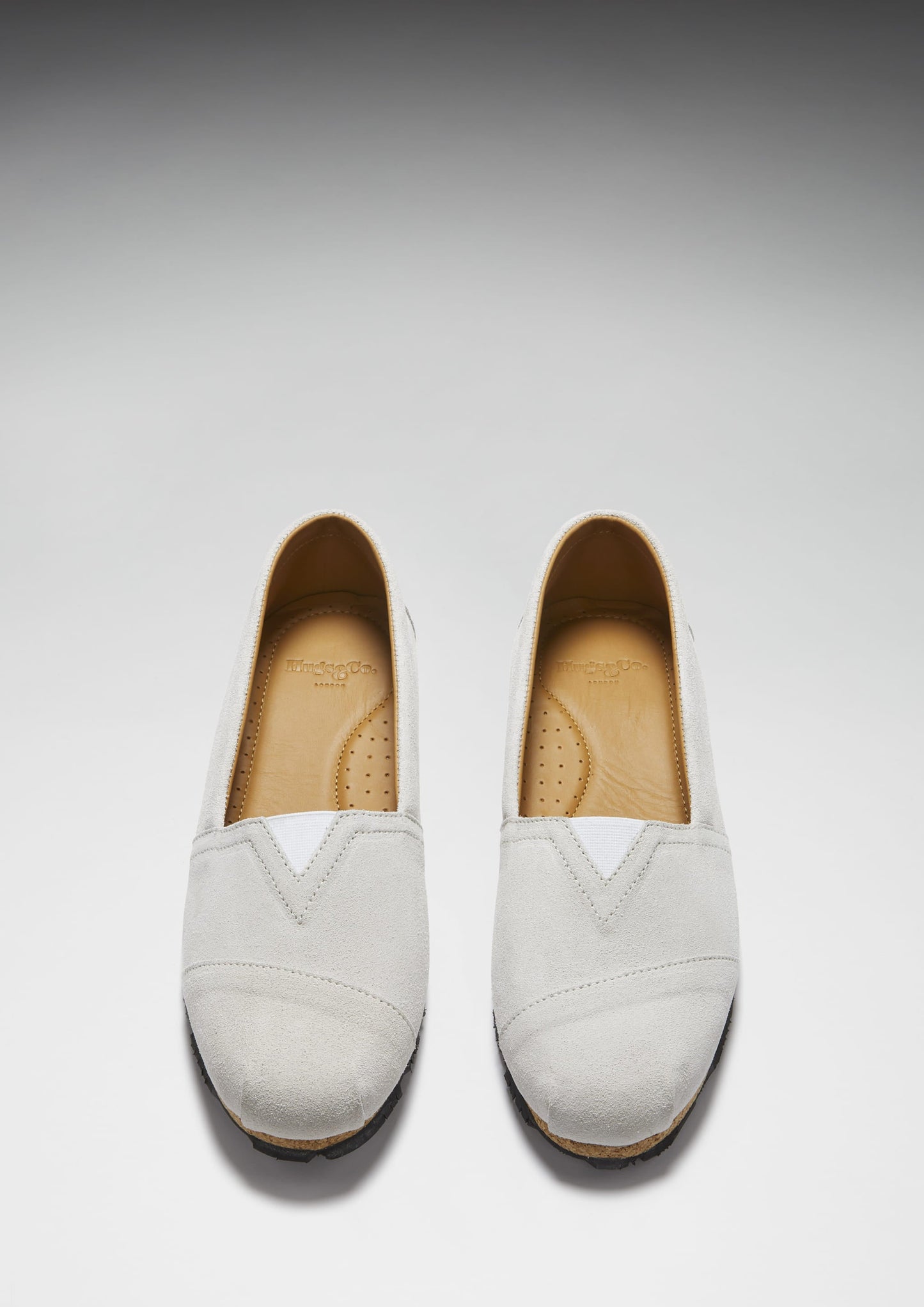 Pair of white loafers on a light gray background