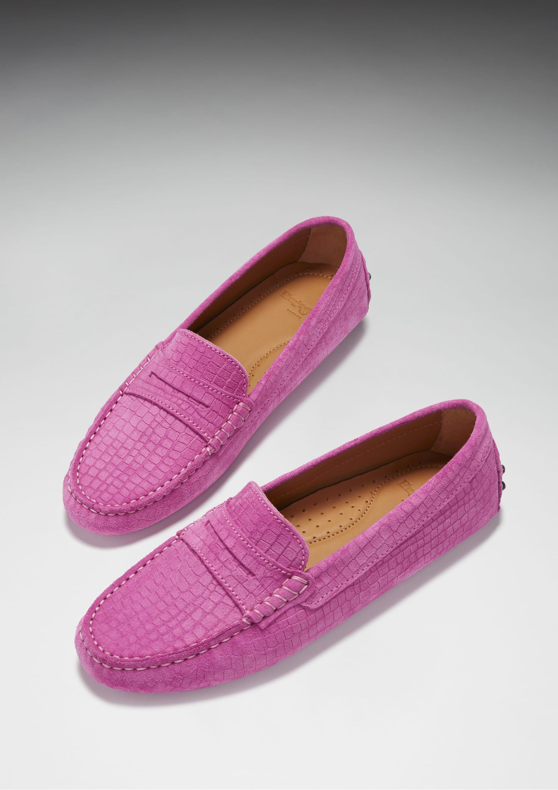 Pair of pink loafers on a light gray background