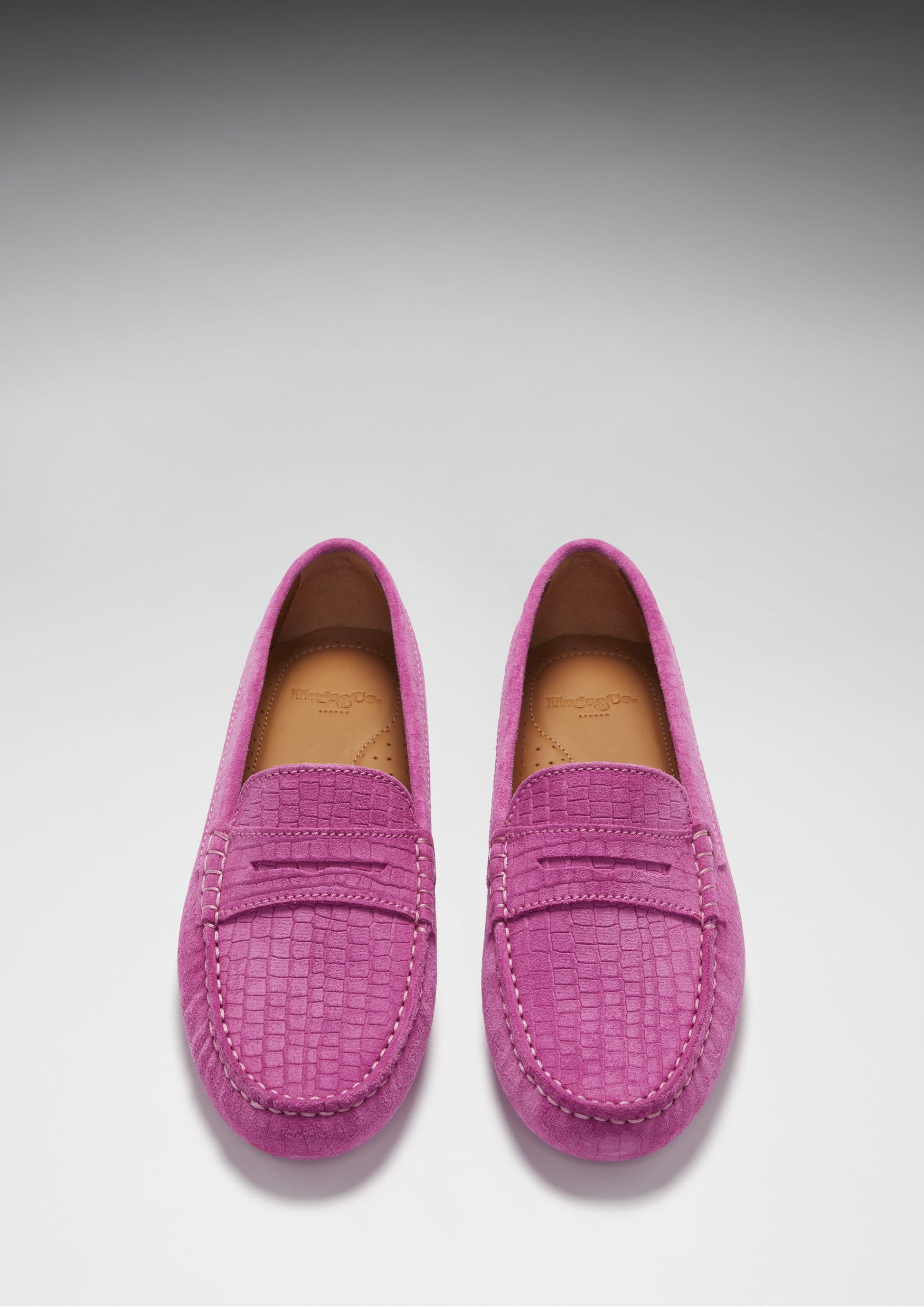 Pair of pink loafers on a light gray background