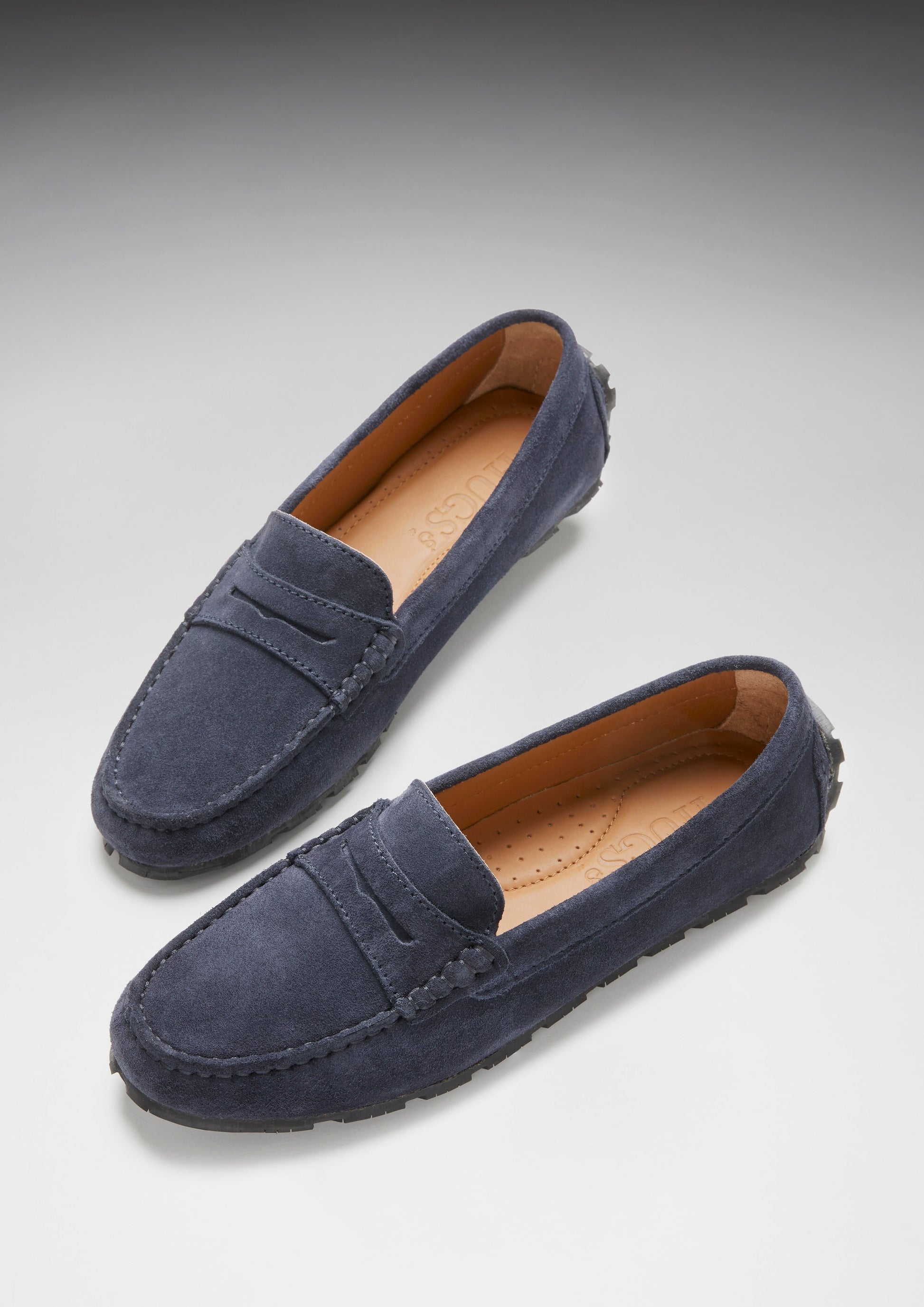 Pair of navy blue loafers on a light gray background