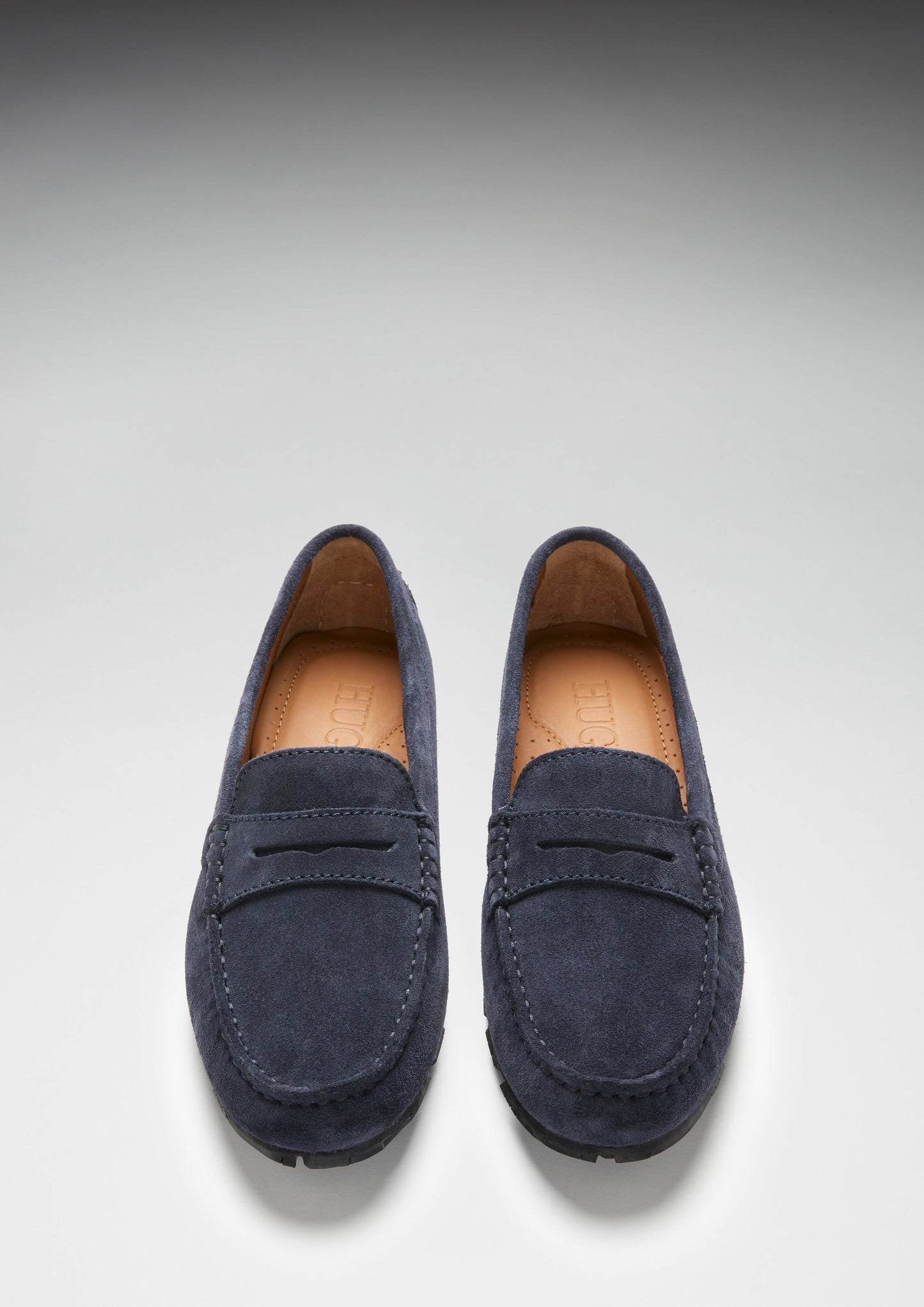 Pair of navy blue loafers on a light gray background