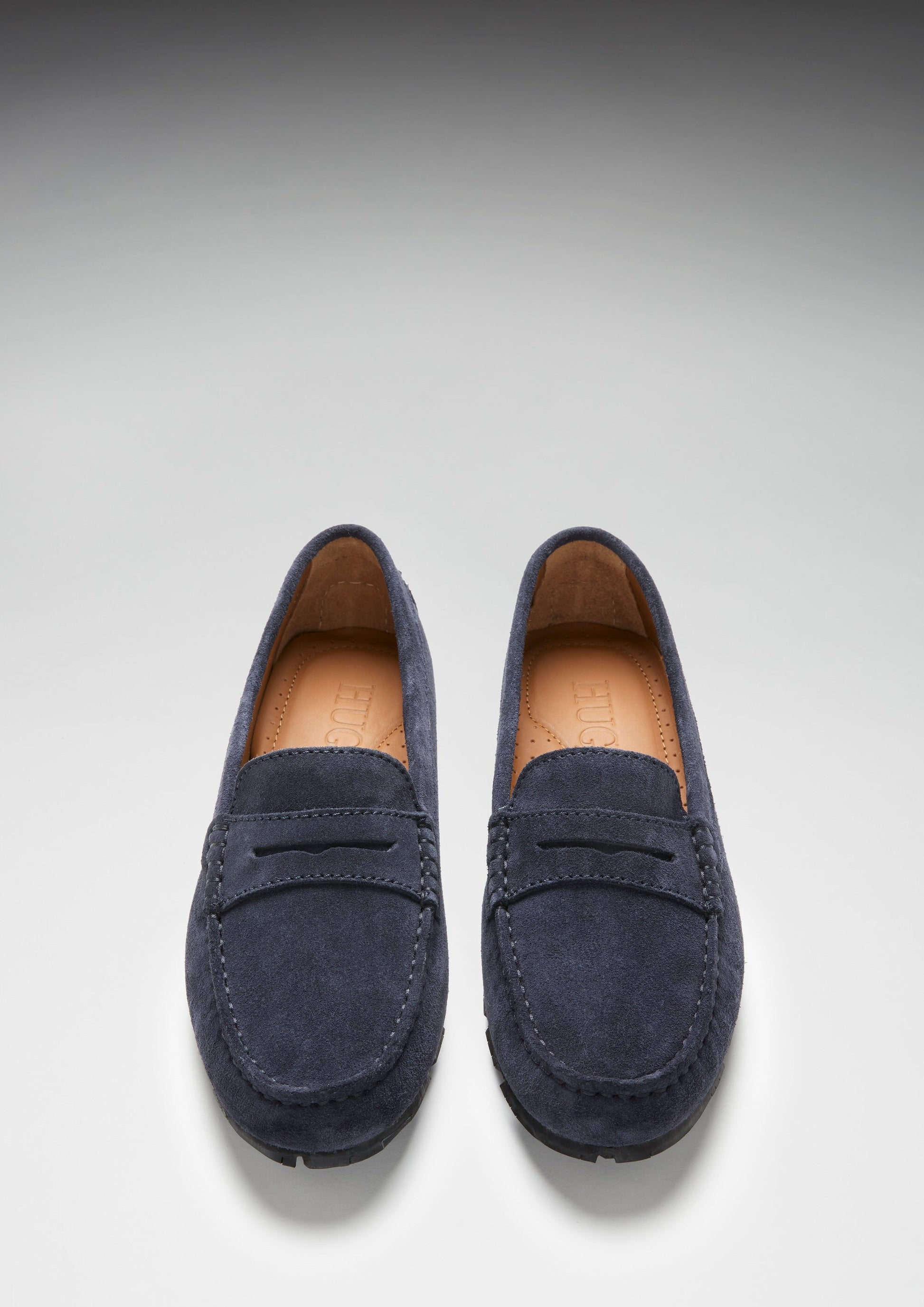 Pair of navy blue loafers on a light gray background