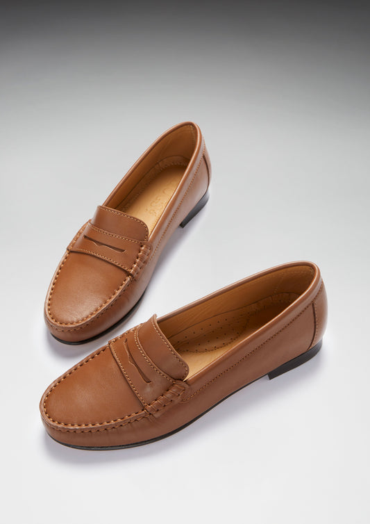 Pair of brown loafers on a light gray background