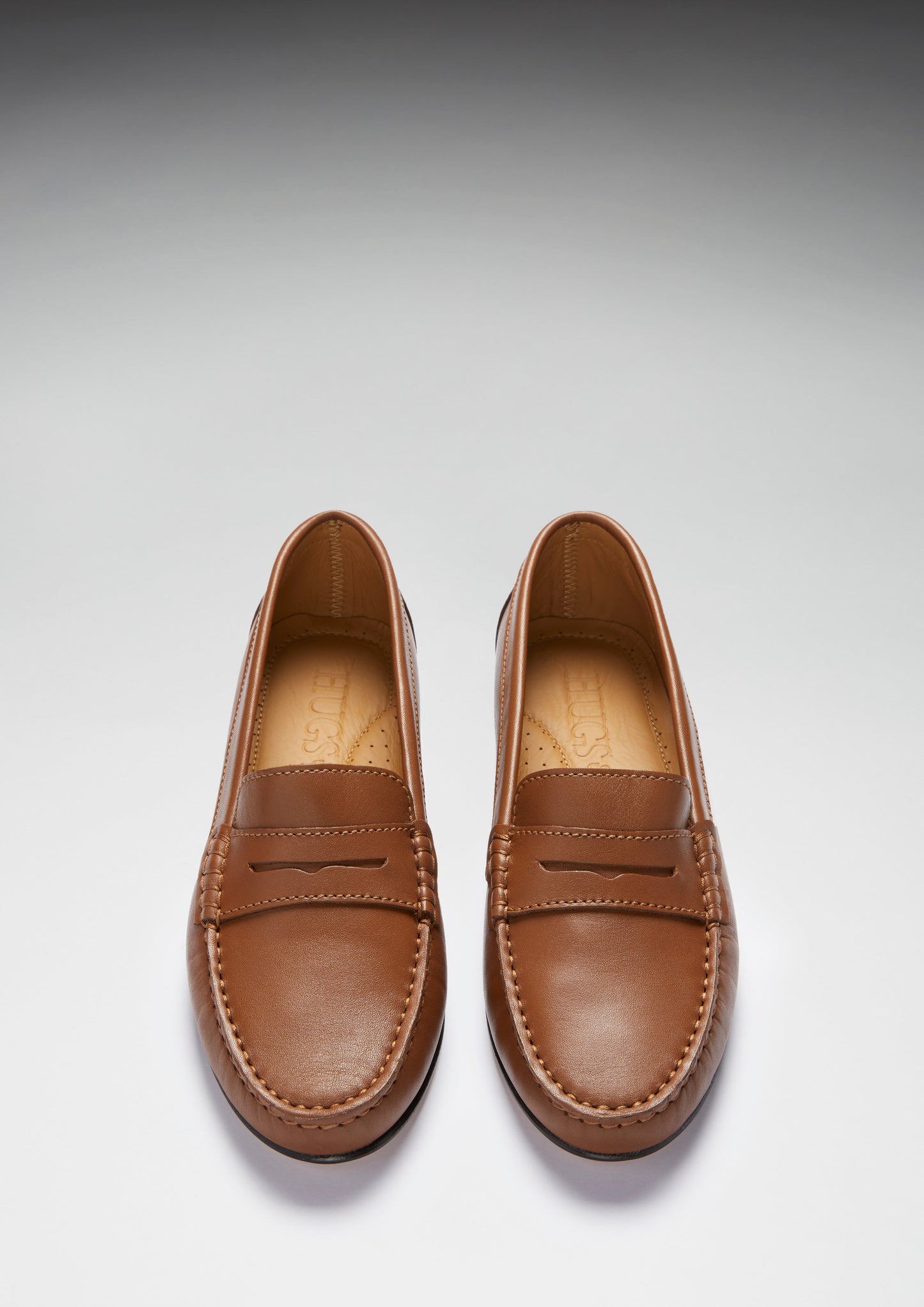 Pair of brown loafers on a light gray background
