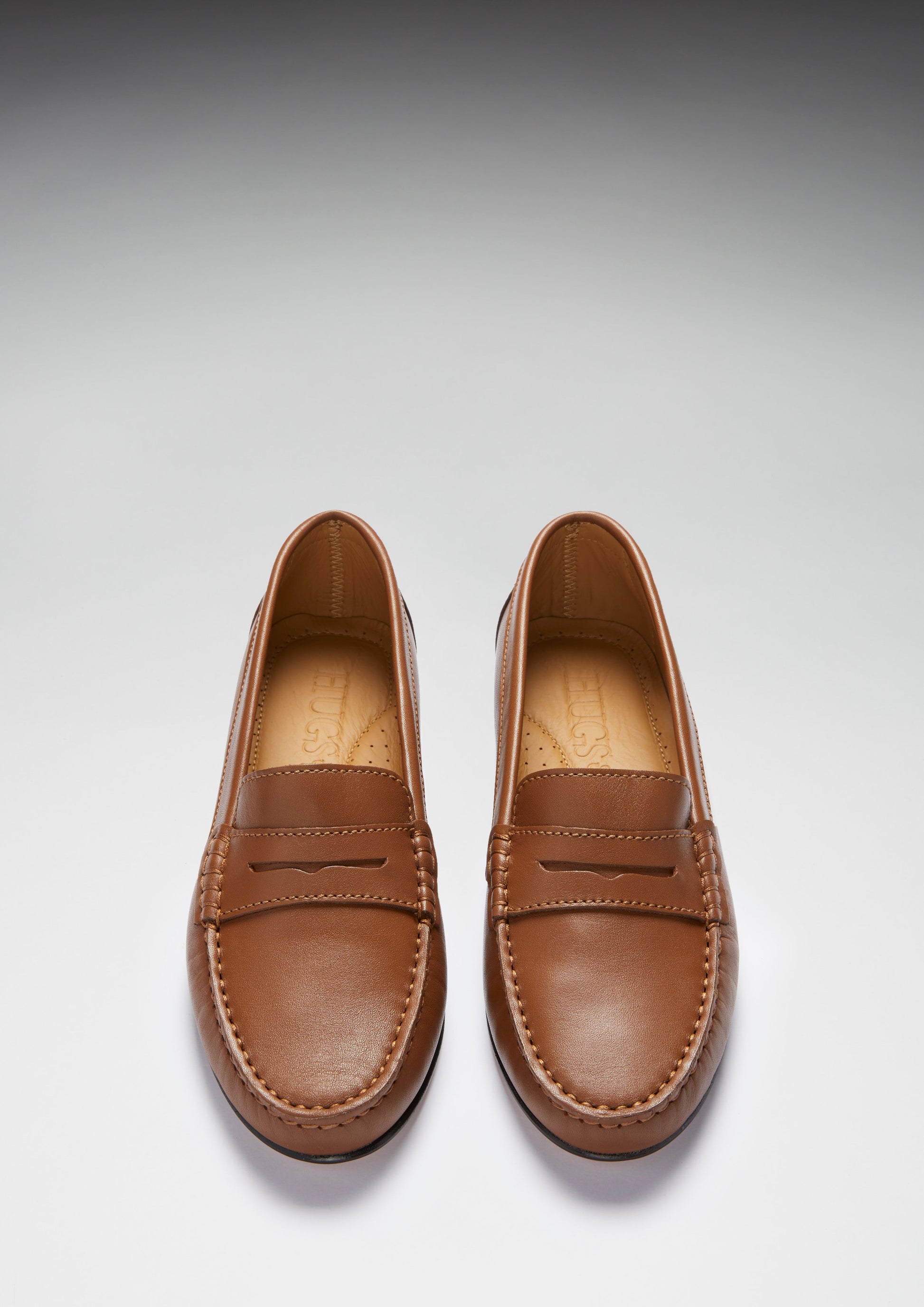 Pair of brown loafers on a light gray background