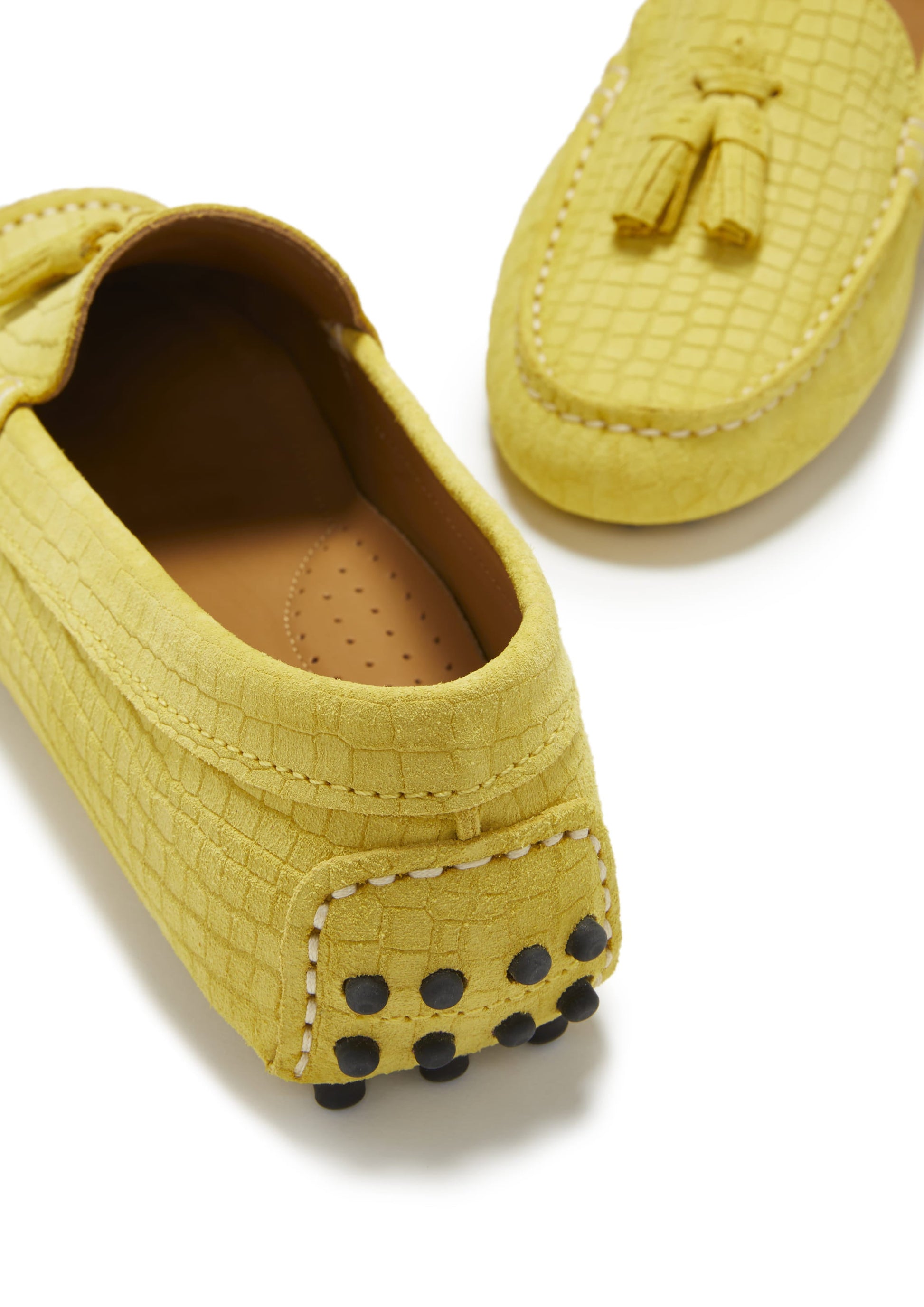 Yellow loafers with a textured pattern on a white background