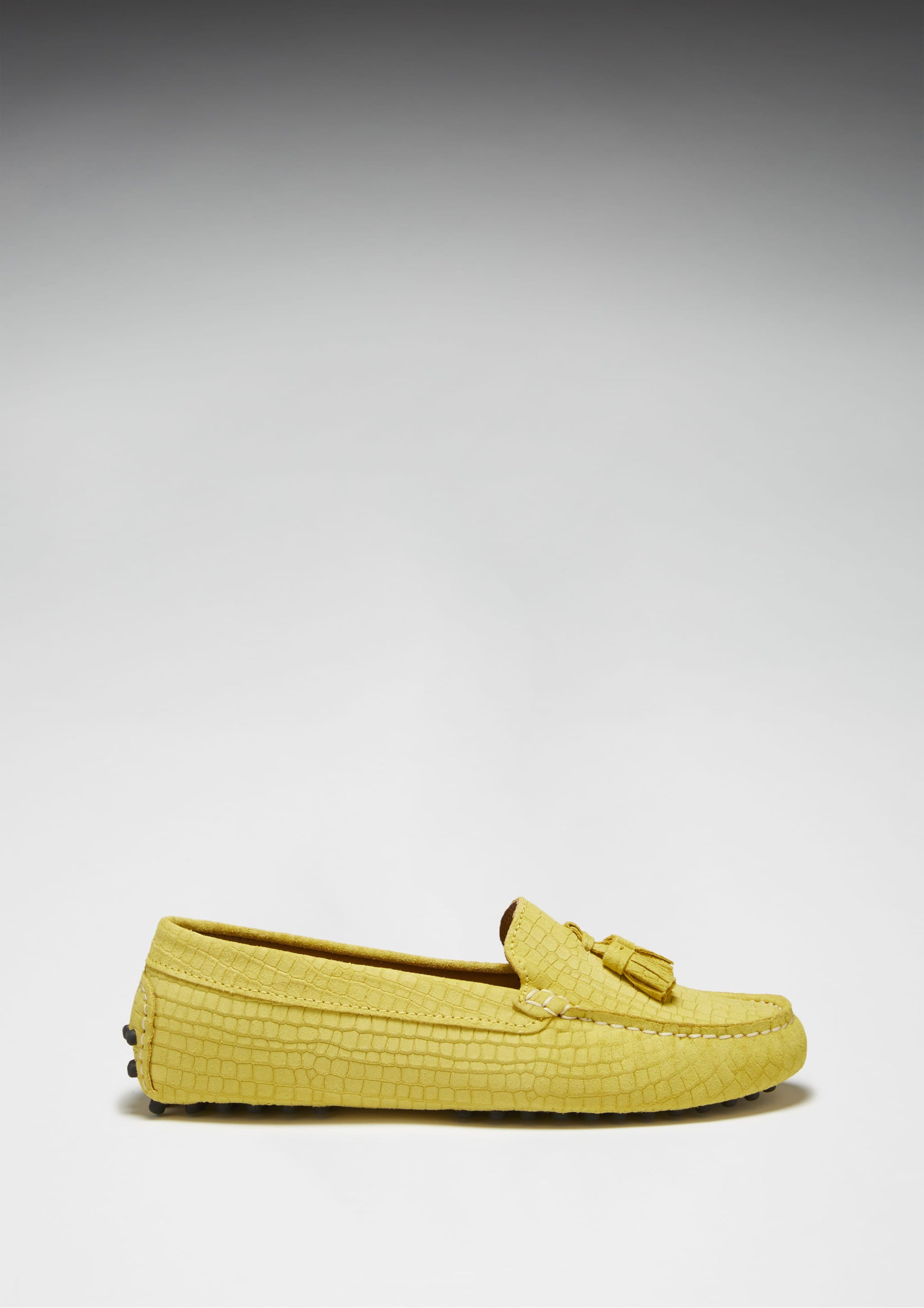 Yellow loafers with a textured pattern on a light gray background