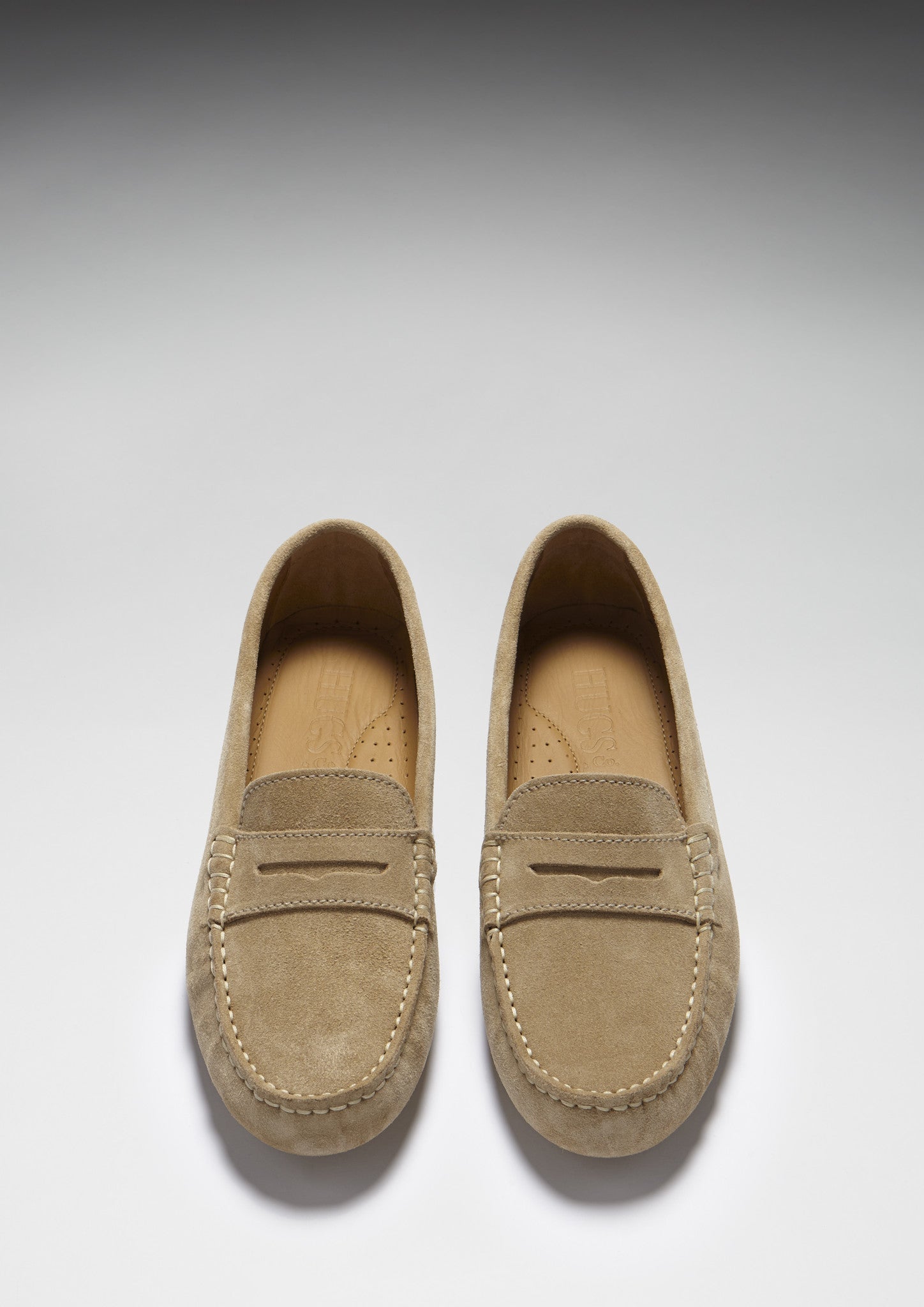 Pair of tan loafers on a light gray background