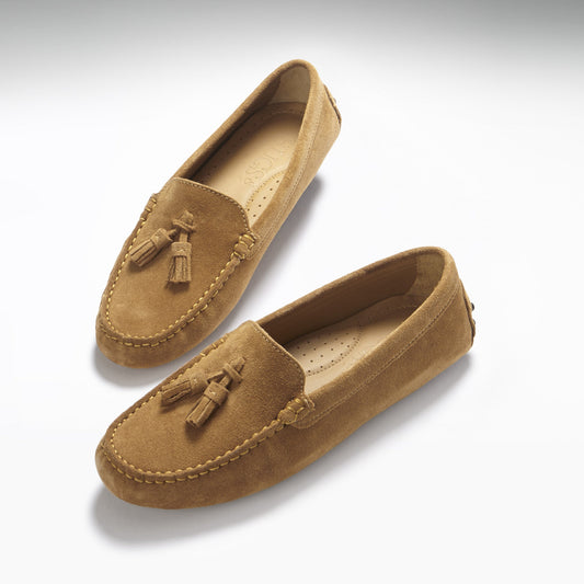 Pair of tan loafers with tassels on a white background