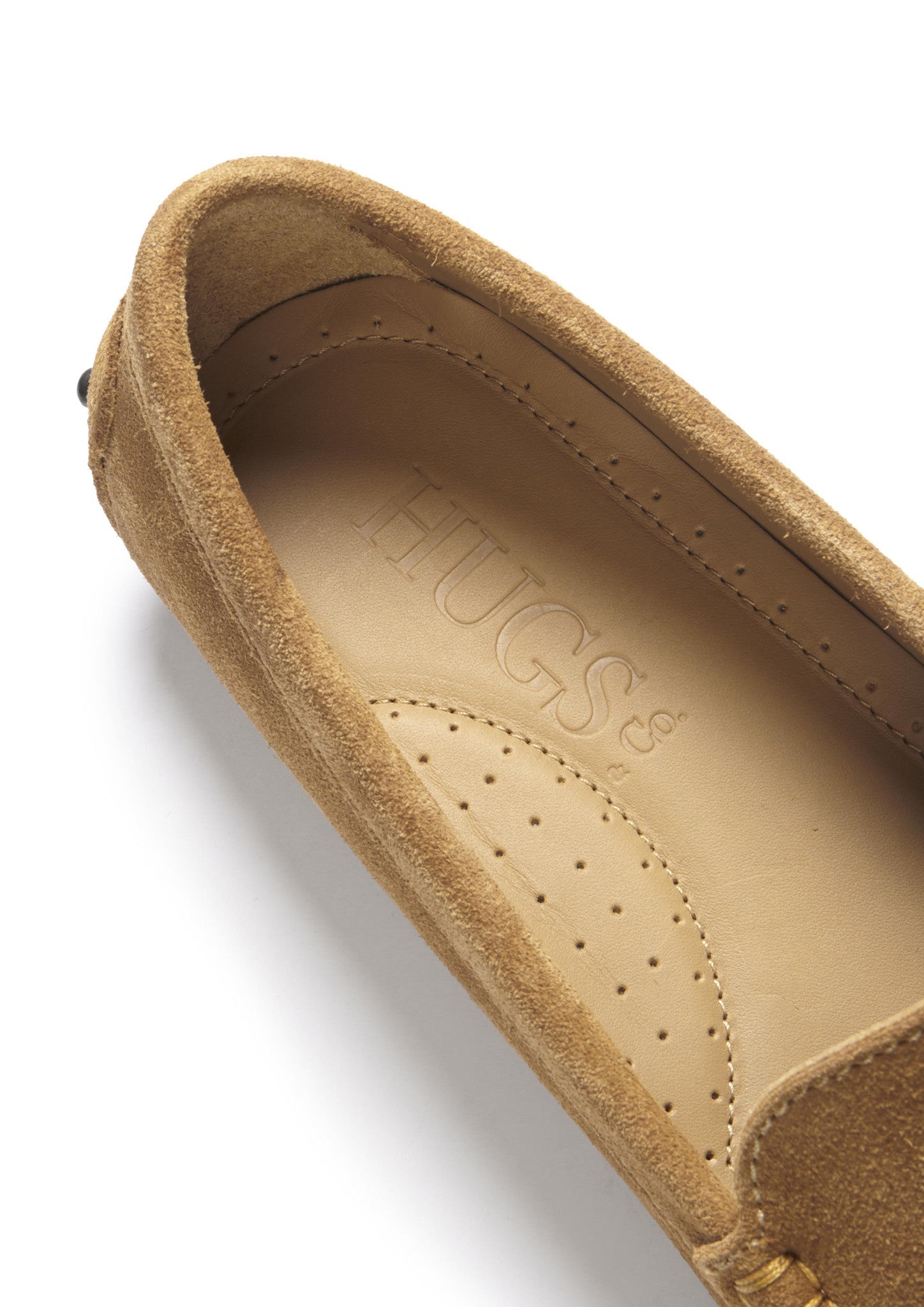 Close-up of a brown shoe with 'HUGS' branding on a white background