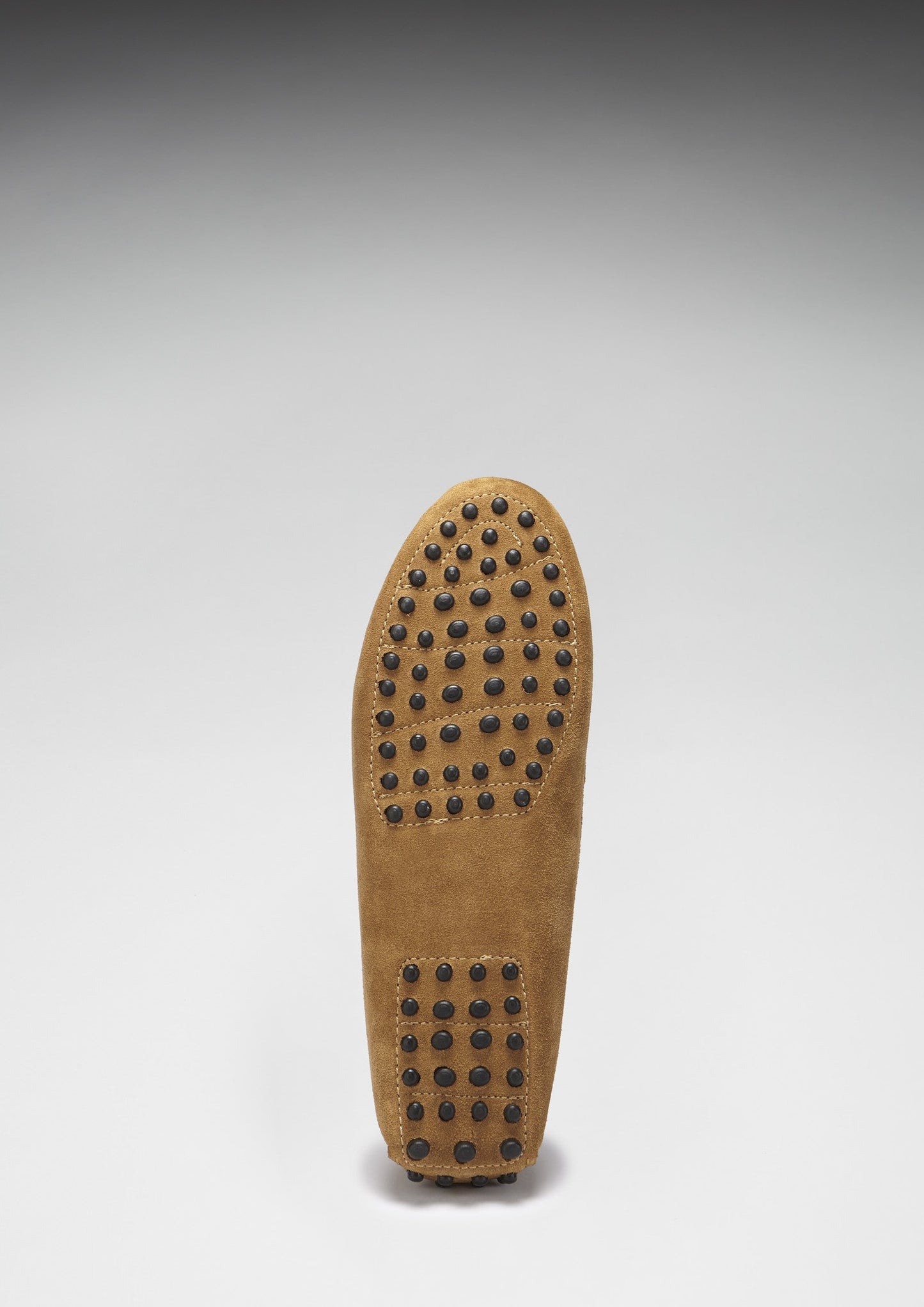 Brown shoe insole with textured surface on a gray background