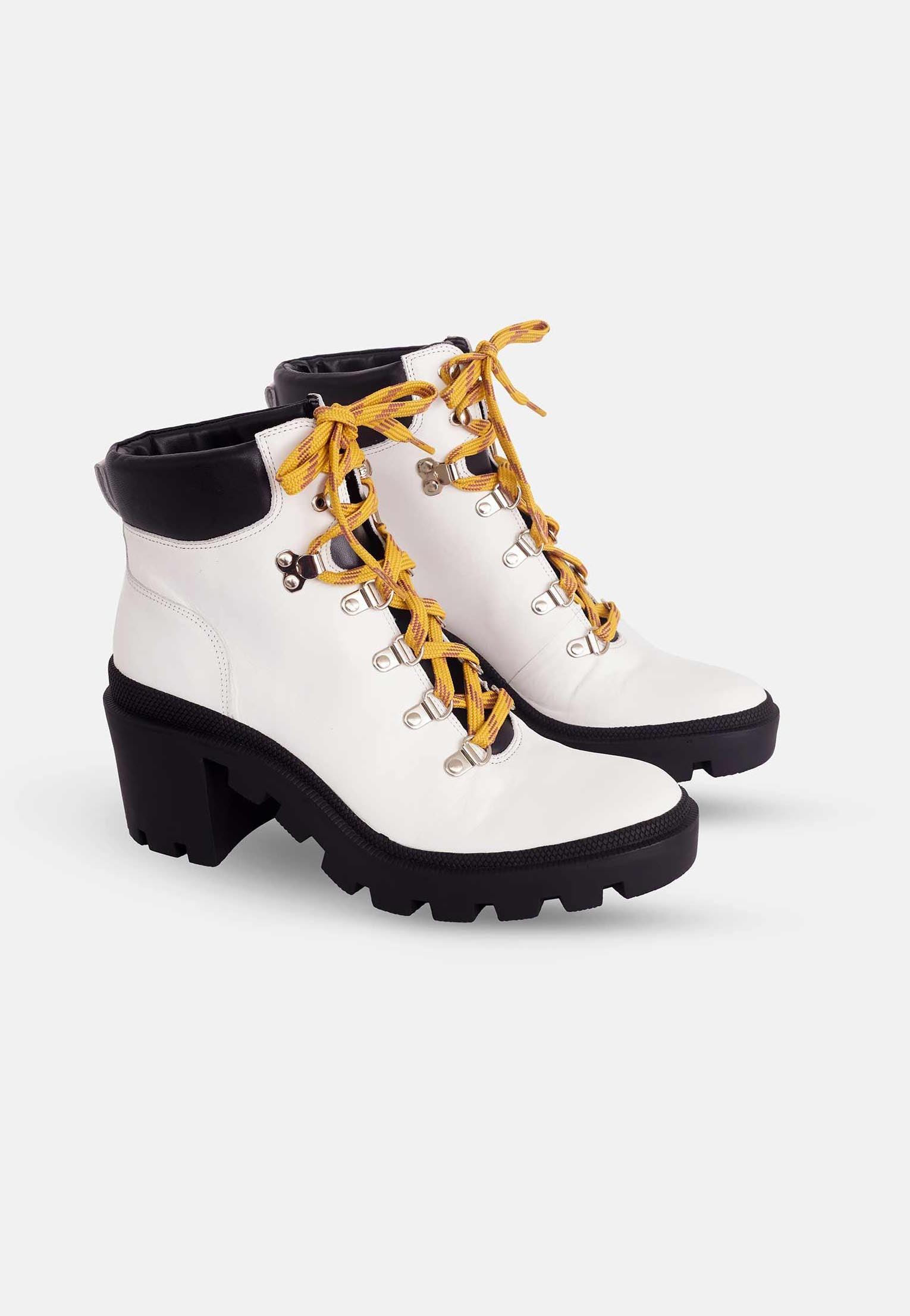 White boots with yellow laces on a white background