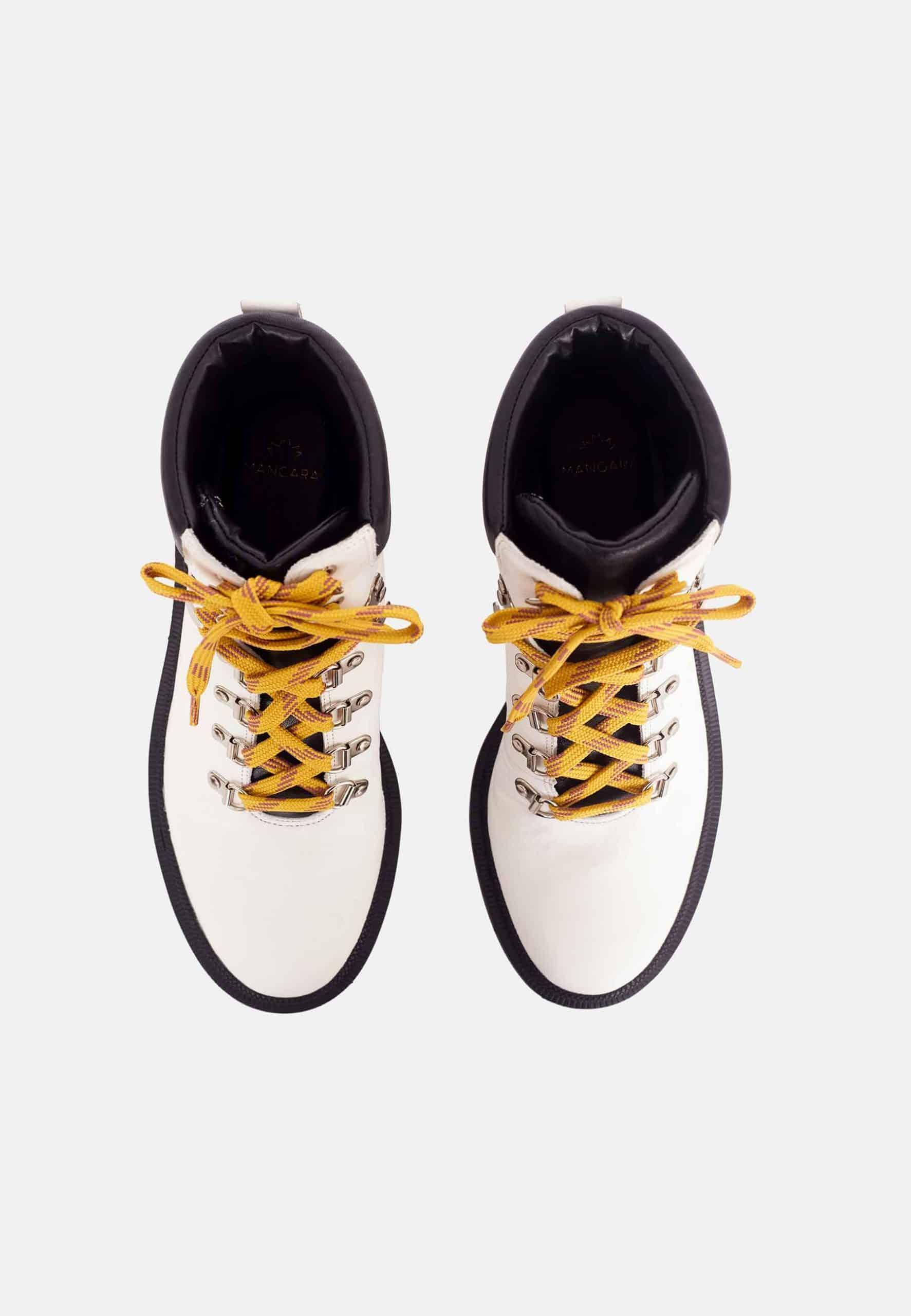 White boots with yellow laces on a white background