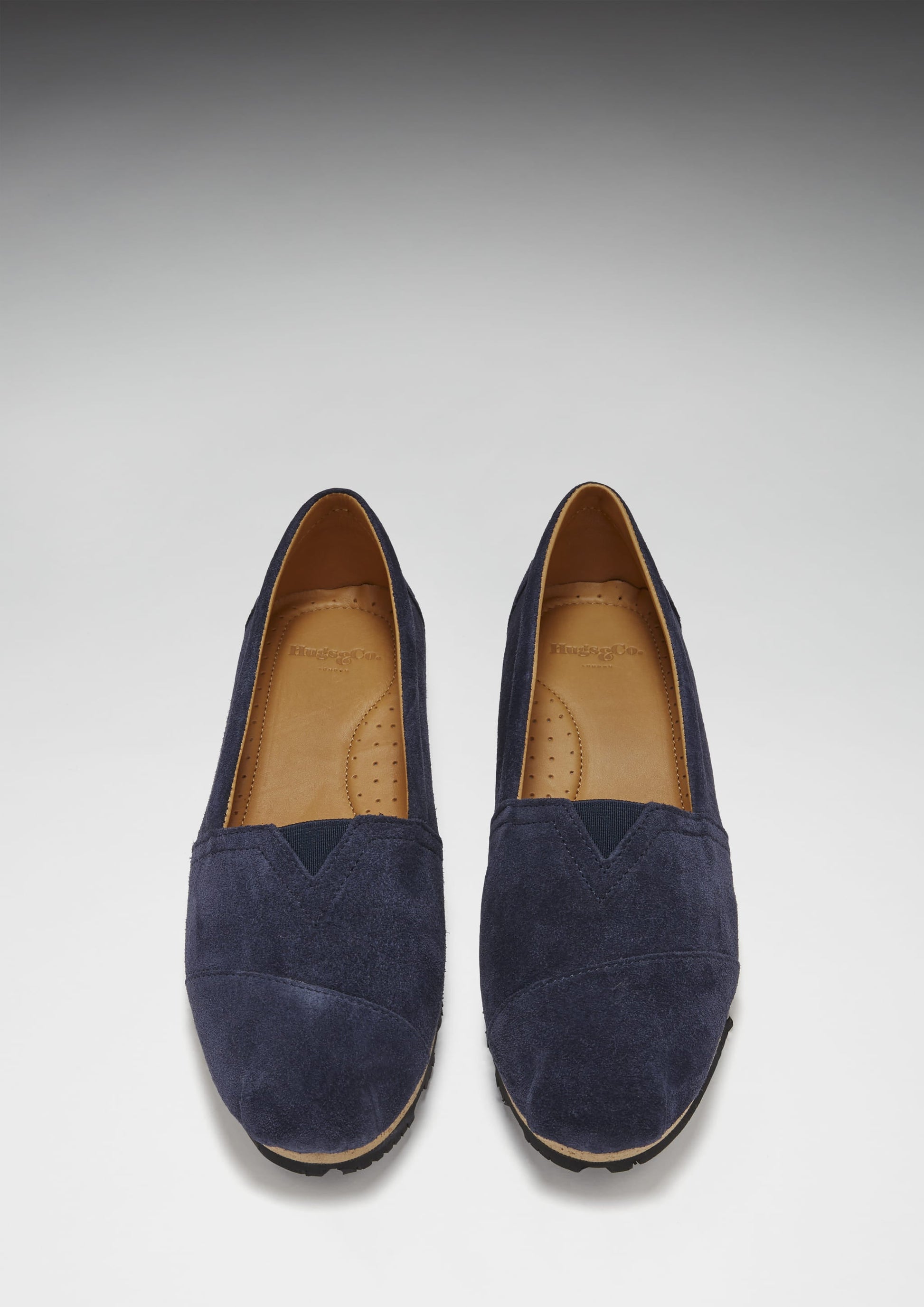 Pair of navy blue suede shoes on a light gray background