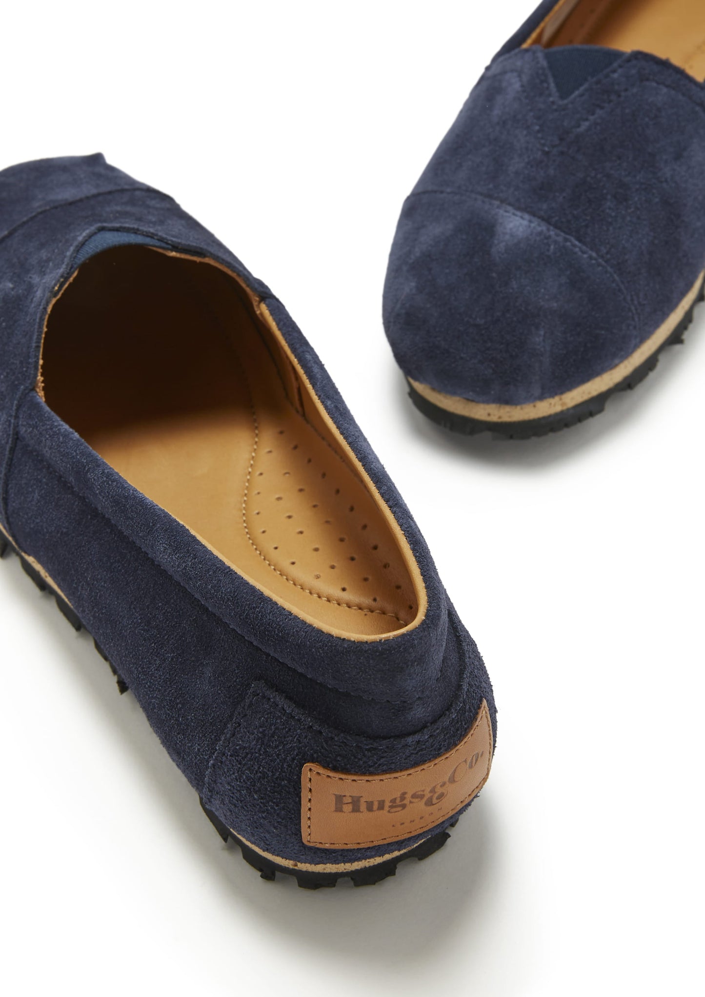 Navy blue loafers with a brown insole and brand label on a white background