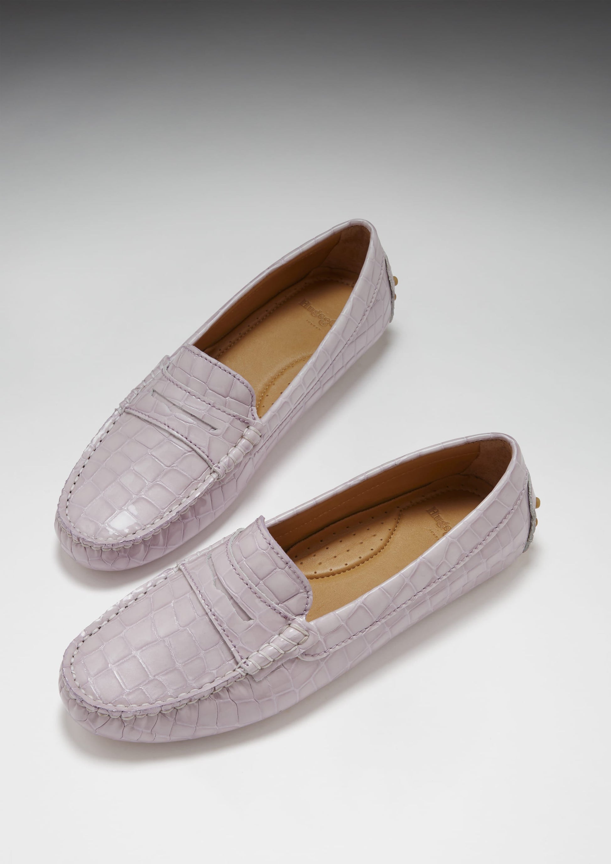 Pair of lavender loafers on a light gray background