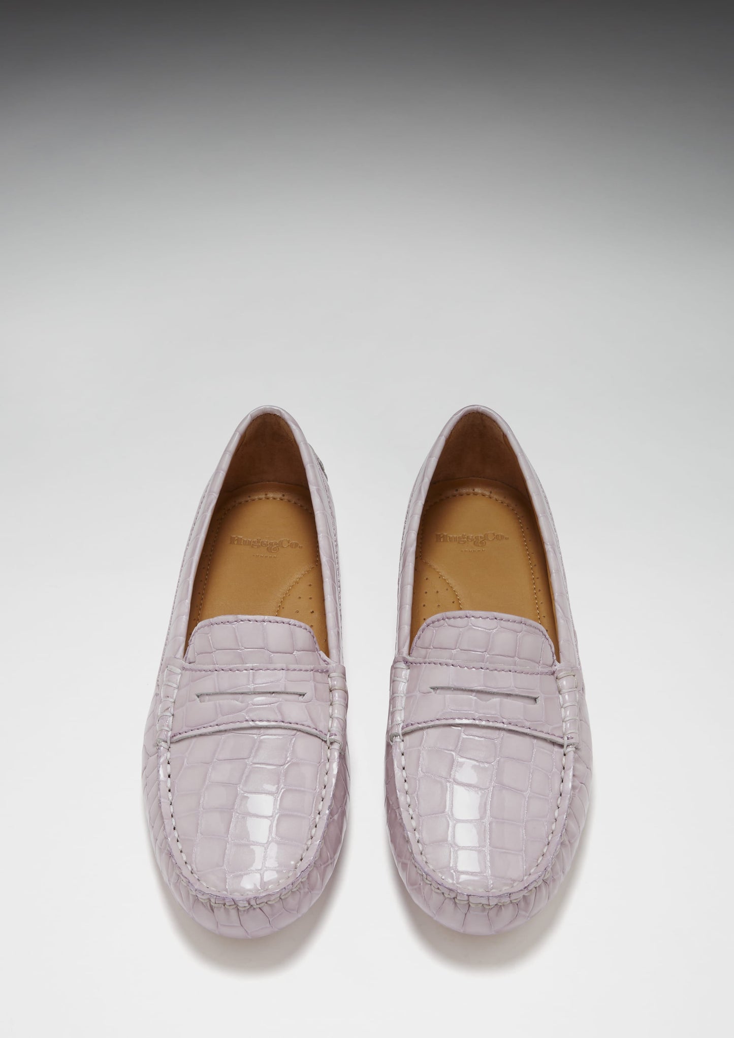 Pair of light purple loafers on a white background