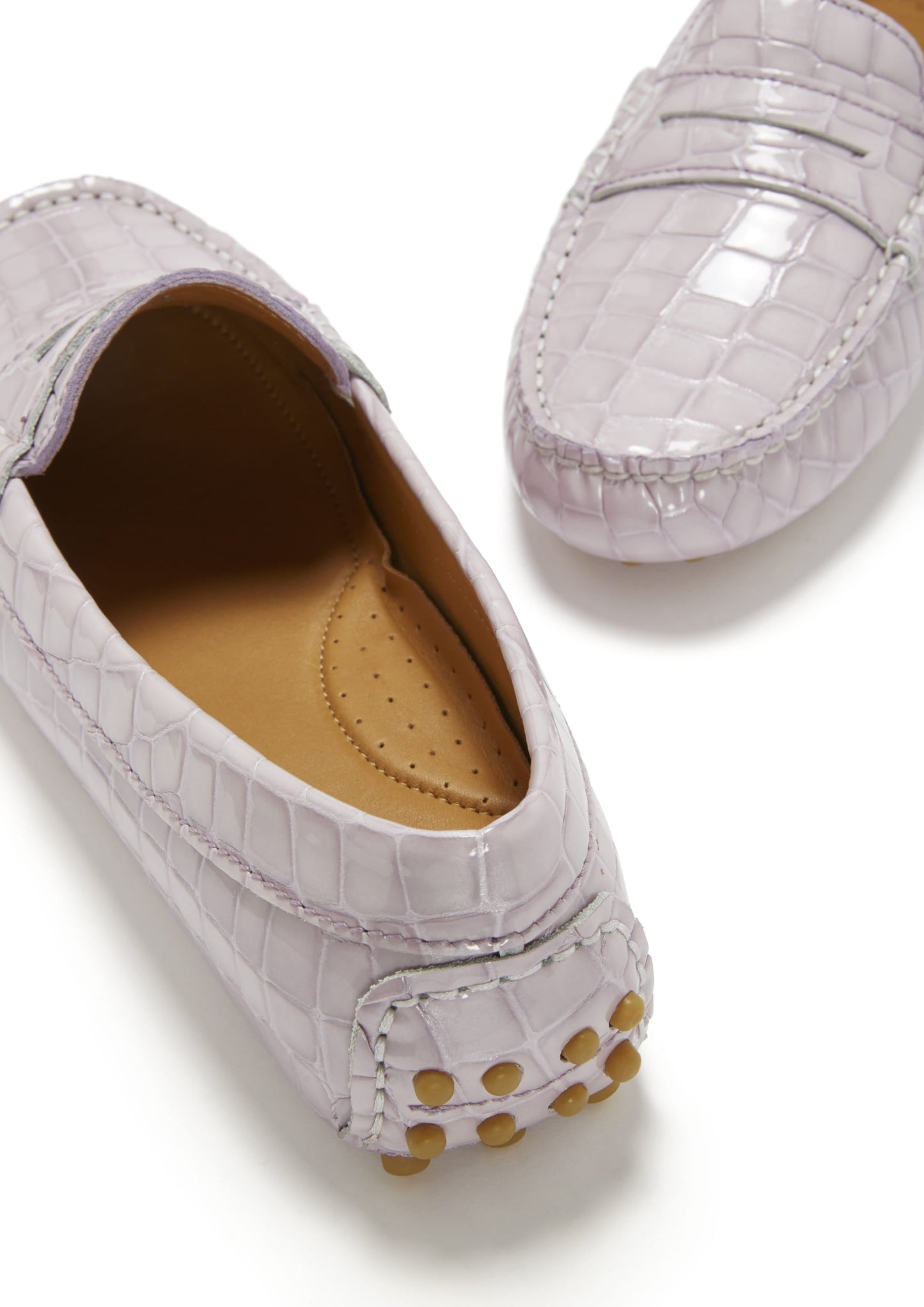 Pair of light purple loafers with textured pattern on a white background