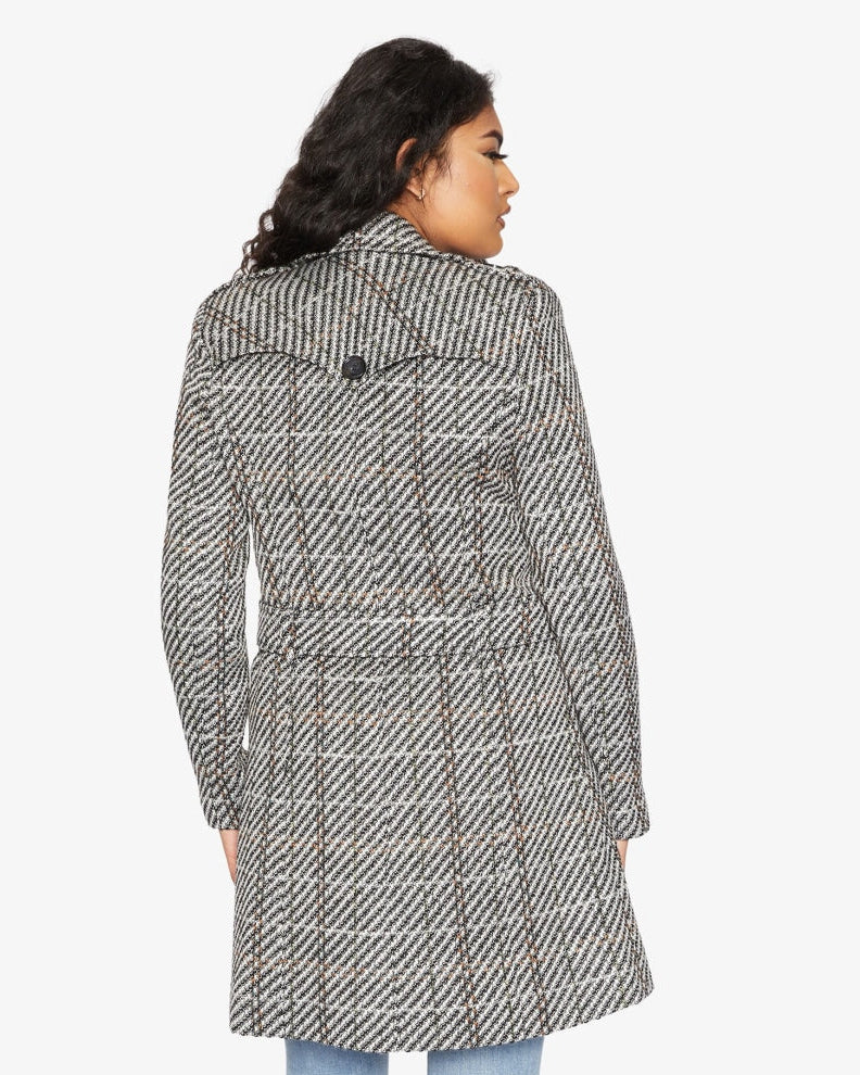 Woman wearing a patterned coat on a white background