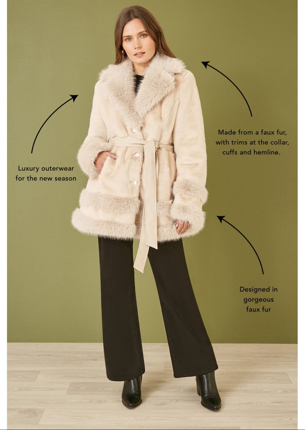 Woman wearing a cream faux fur swing coat with text describing the product on a green background